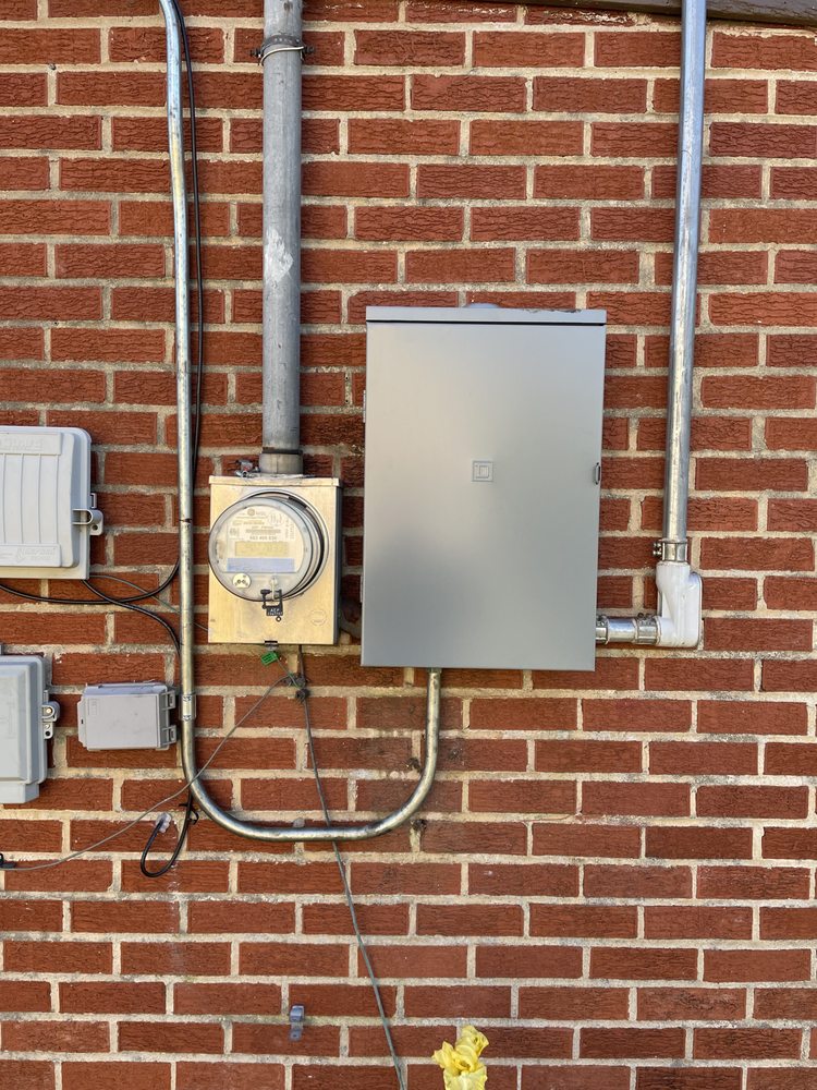 New meter base and outdoor panel with conduit on a brick wall
