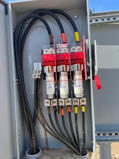 Open fused disconnect with three cartridge fuses and phase-taped conductors